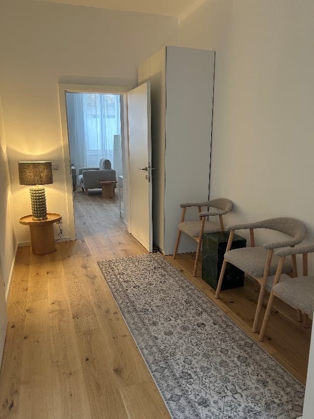 Wartebereich mit zwei Stühlen und Blick in den Therapieraum